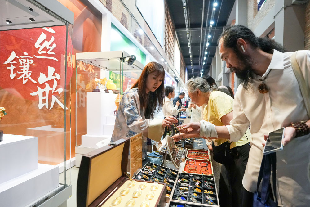 2026年5月15日，市民游客在北京朝阳公园的首届中国新文创市集暨潮玩游园会的花丝镶嵌大师工坊参观选购。新华社记者 鞠焕宗 摄
