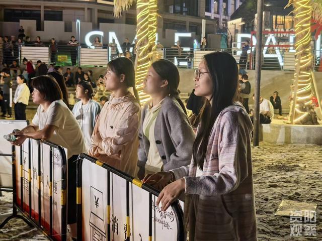 22岁的梁倩和两个朋友放声跟唱。全媒体记者 阳洋 摄
