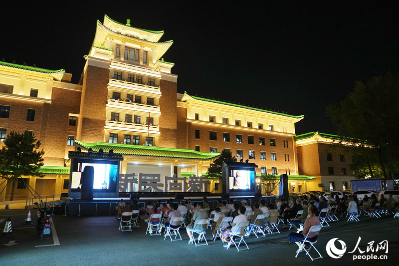8月21日，市民游客在长春历史文化博物馆前的露天影院观看电影。人民网记者 李洋摄