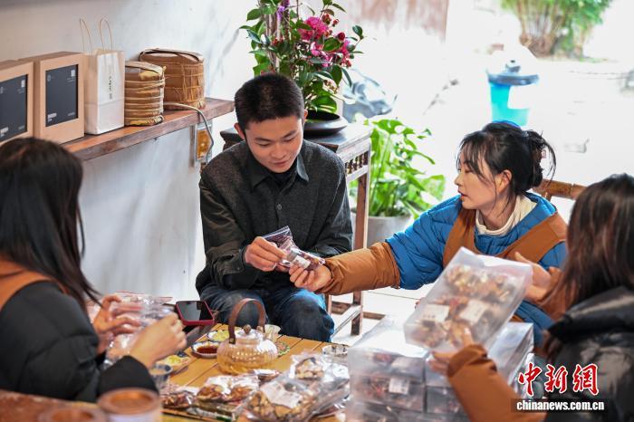 1月29日，张昀澂(左二)正在与老街的邻居品茶聊天。中新社记者 刘忠俊 摄