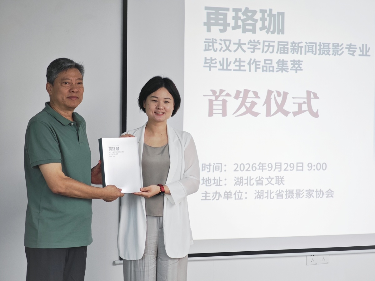 《再珞珈:武汉大学历届新闻摄影专业毕业生作品集萃》编著章克刚(左)向湖北省摄影家协会赠书后,与湖北省摄影家协会驻会负责人、秘书长王艺杰合影。.jpg