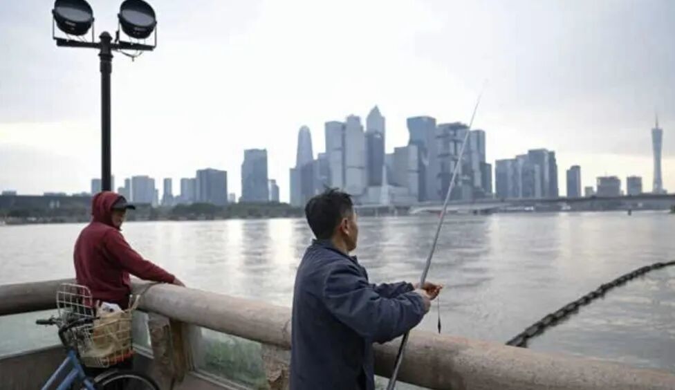 2026年2月9日,广东广州。在科技公司扎堆的琵洲CBD对岸,有市民在工作日悠闲地钓鱼。(图/Zhong)