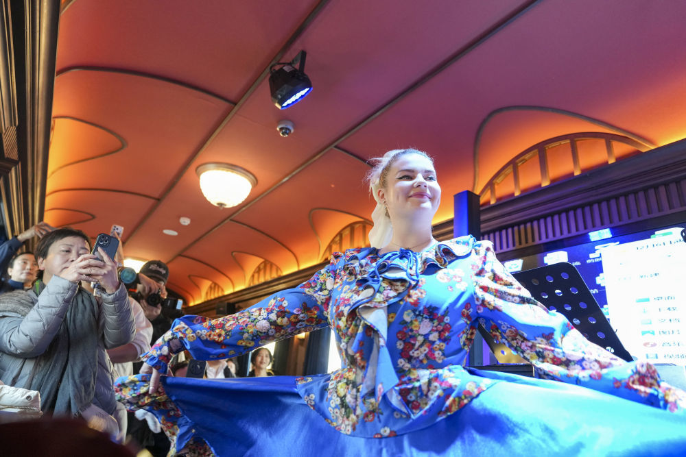 2025年12月6日，演员在黑龙江省“伊春号”旅游专列车厢中表演。当日，“伊春号”旅游专列投入试运行，40余名受邀体验的游客乘专列由哈尔滨站出发，去往亚布力滑雪旅游度假区。2025年以来，中国铁路哈尔滨局集团有限公司陆续开行了多趟旅游列车，将特色体验、民俗展示、定制化服务等进行融合，满足游客需求，服务旅客出行。