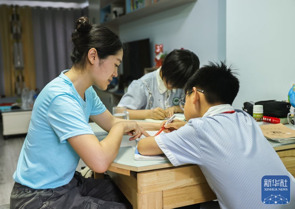 ↑6月2日，梁洪美在安徽阜阳家中辅导孩子。