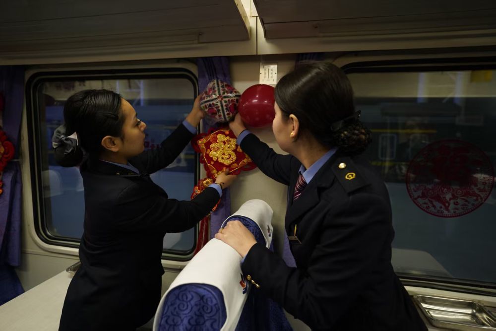 列车工作人员正在装点车厢，为列车增添年味。新华社记者 白志强 摄