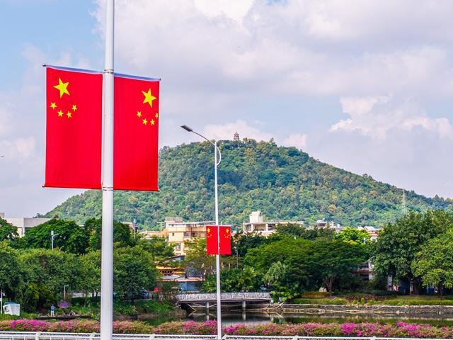 大良龙盘大桥上悬挂的国旗与远处的顺峰山。