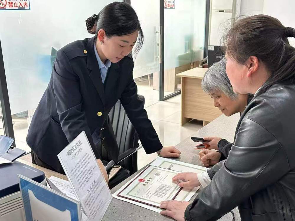 锦州市古塔区政务服务中心窗口工作人员为群众讲解营业执照领取及相关后续办理流程，协助完成执照发放环节（2026年3月11日摄）。（受访单位供图）