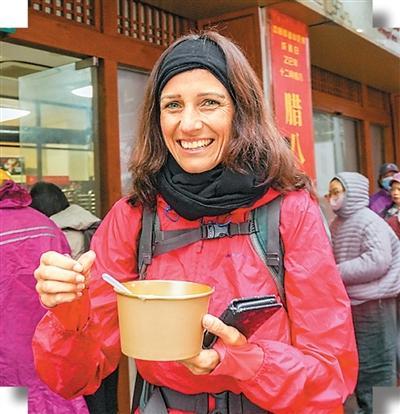 图为近日,在上海静安寺,外国游客品尝中国美食腊八粥。