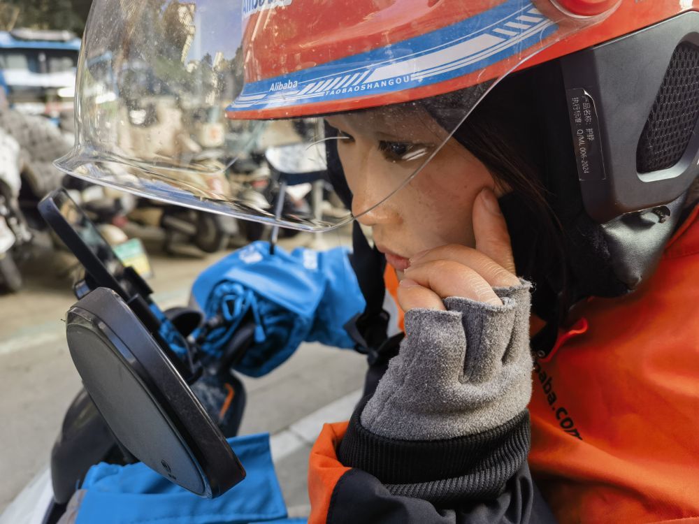 外卖骑手朱亭亭在查看雨雪天气送餐时脸上摔出的伤。新华社记者 朱青 摄