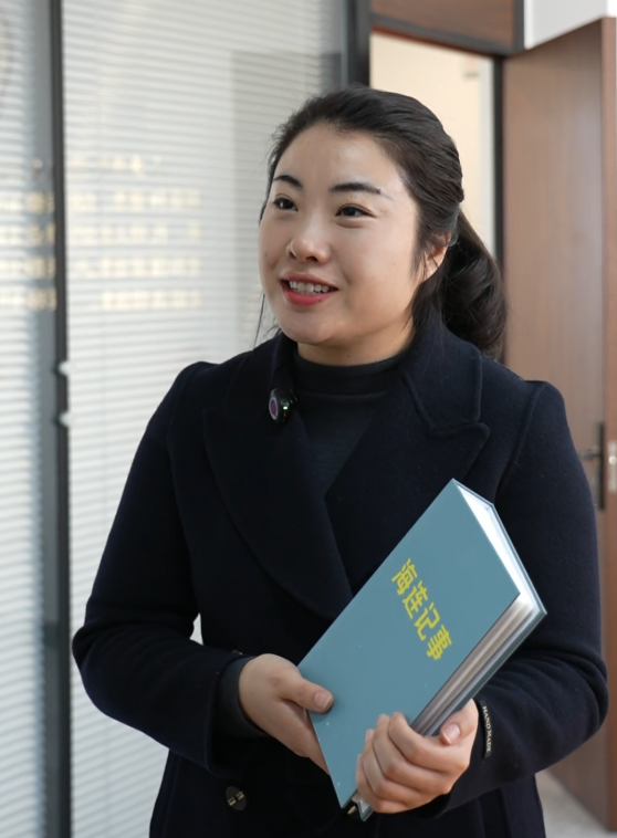 全国人大代表李肖娜向记者展示《海连记事》相册。