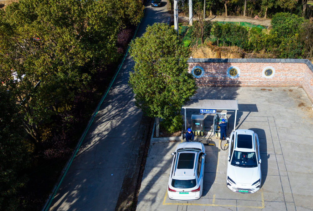 2026年1月11日,国网鄂州供电公司工作人员对鄂州市鄂城区西山街道小桥村充电站的充电设备进行巡检(无人机照片)。新华社记者 肖艺九 摄