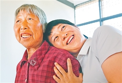 大湾村党总支第一书记余静(右)帮脱贫户张邦若设置智能手机后,放松地靠在她的肩膀上聊起了天。