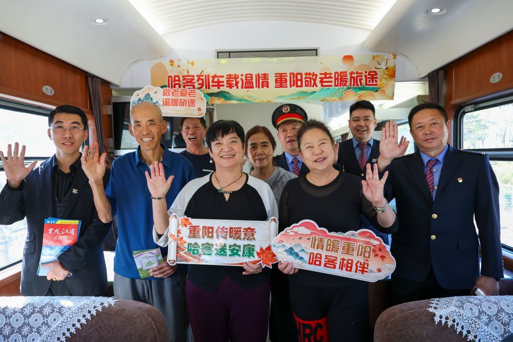 哈尔滨至海口列车保障老年乘客南下越冬。10月16日人们在从哈尔滨西开往海口的Z114次列车上合影。(新华社记者 王松 摄)