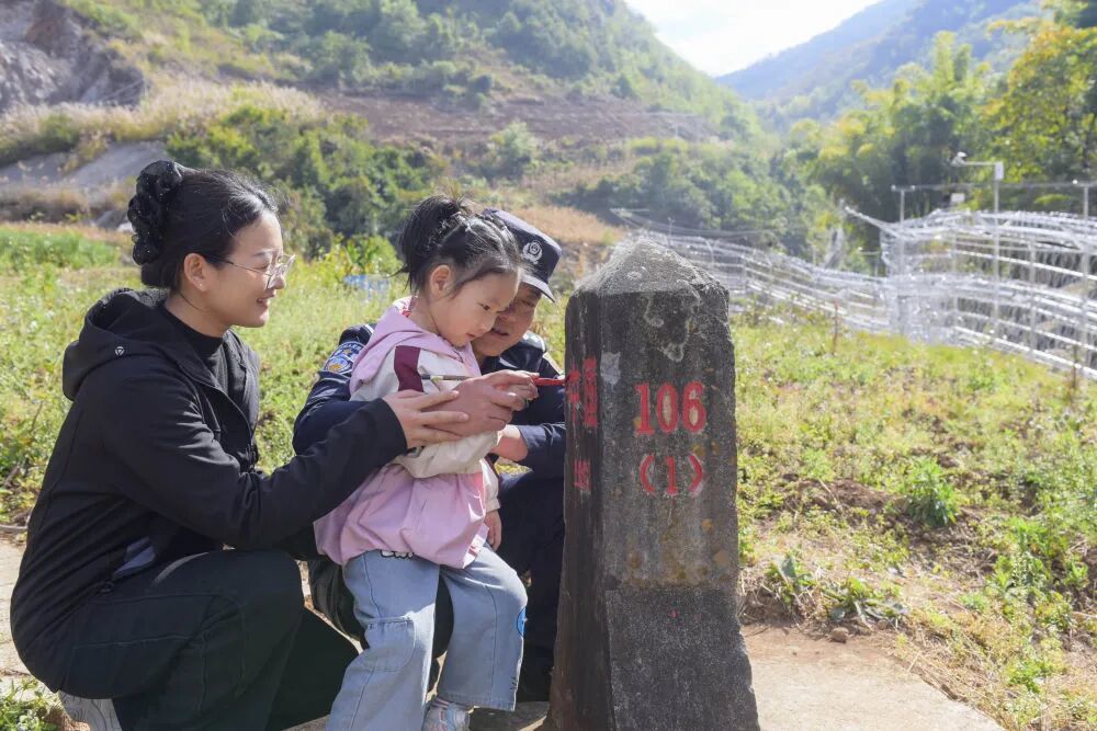 杨睿带着妻女为界碑描红。新华社发