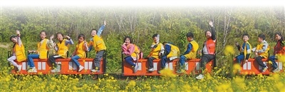 重庆市北碚区歇马街道虎头村，青少年们乘坐小火车感受乡村田园之美，乐享春日假期。　