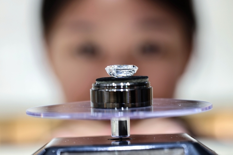 2025年7月9日，河南柘城的一家人造钻石企业钻石生产、销售两旺。河南柘城被誉为“钻石之都”，官方数据显示，柘城县年产金刚石单晶60亿克拉、金刚石微粉150亿克拉。图为人造钻石成品吸引消费者观赏。 中新社发 王中举 摄 IC Photo