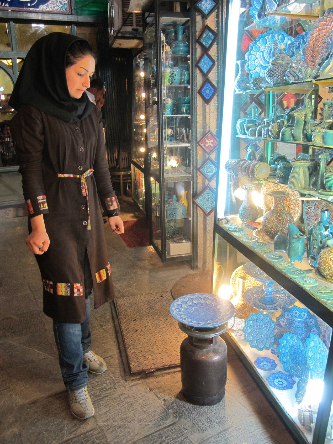 王侯广场的巴扎内,波斯姑娘在自家的工坊兼商铺前加工珐琅盘