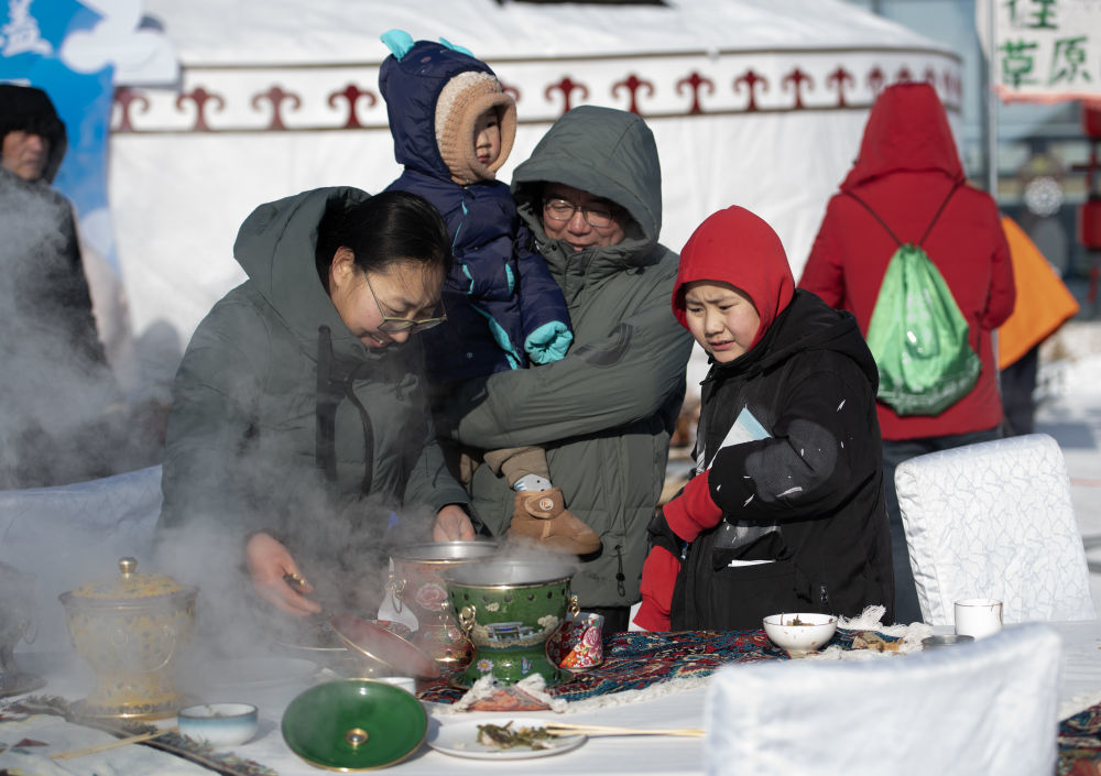 ↑1月10日,游客在内蒙古乌拉盖第三届冰雪文旅主题活动上体验百米长桌宴。新华社发(吴潇莹摄)