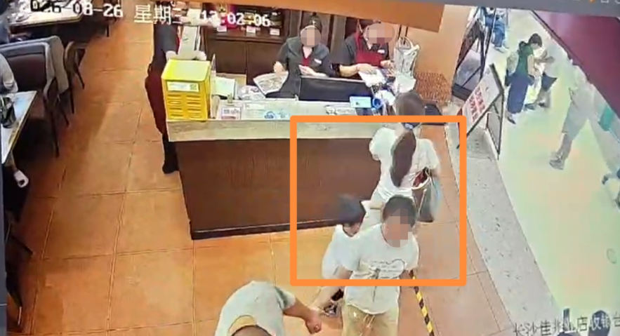 △男童穿过两人间隙的瞬间（监控截图）