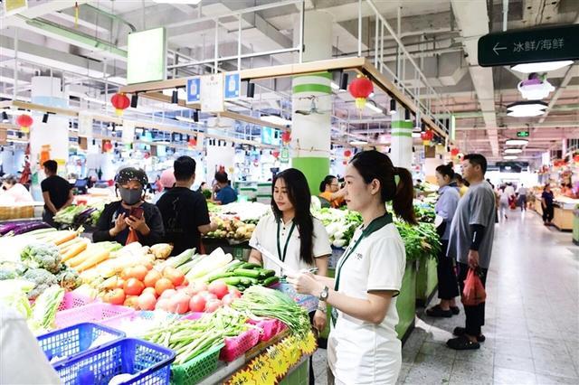 工作人员对菜市场进行每日巡查、统计零售价和批发价。张慧膑 摄