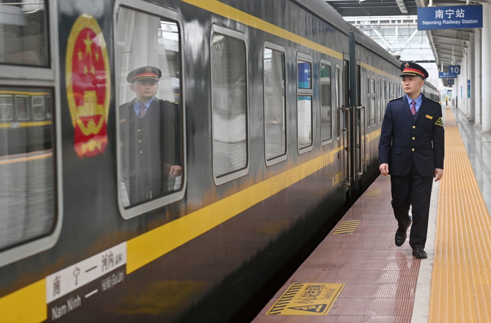 2月11日，在中国广西南宁站，中越国际联运旅客列车列车长黄俊杰在乘客下车后巡视检查列车情况。新华社记者 陆波岸 摄