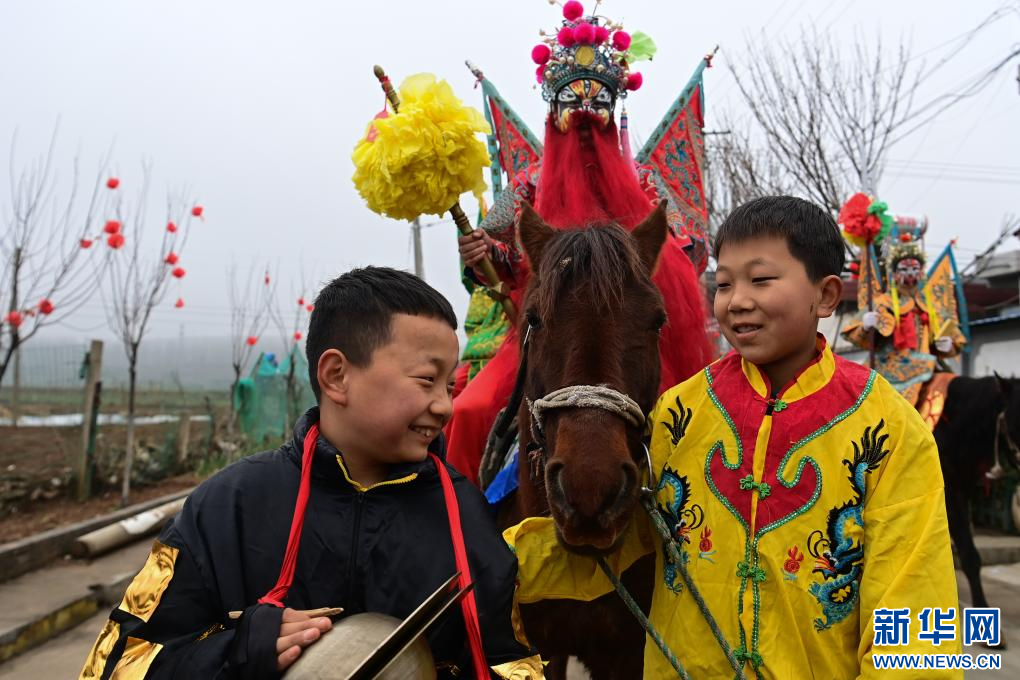 3月2日,陇县黄花峪村社火队的两名小朋友在游演途中交流。新华社记者 邹竞一 摄