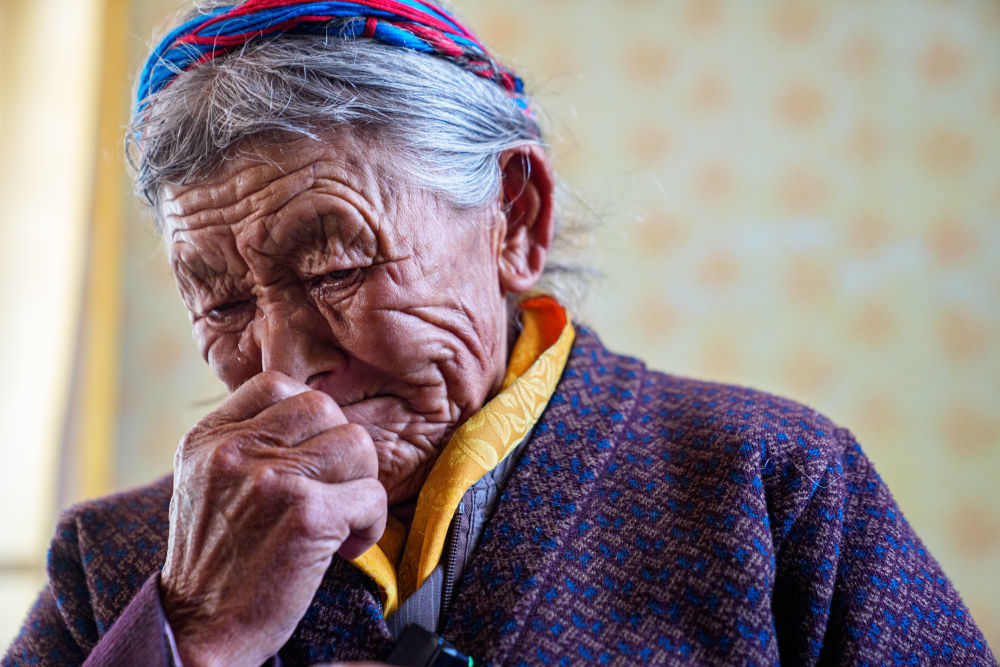 次仁桑姆和家人在宗卡村家中回忆曾经的生活,黯然泪下(3月26日摄)。