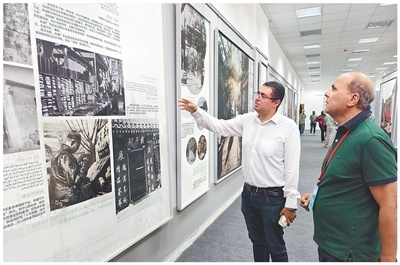 在苏伊士运河大学孔子学院,《金字塔报》记者(右)参观中国文化主题展览。本报记者 宦 翔摄