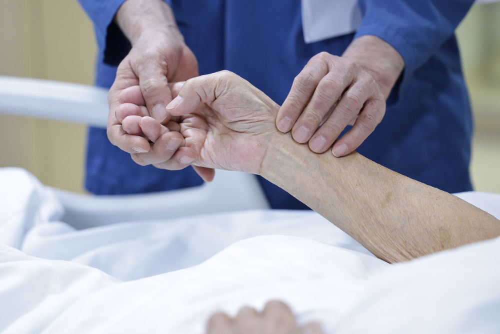 2月9日8时许，急诊科资深主任齐文升在重症监护病房为患者号脉。