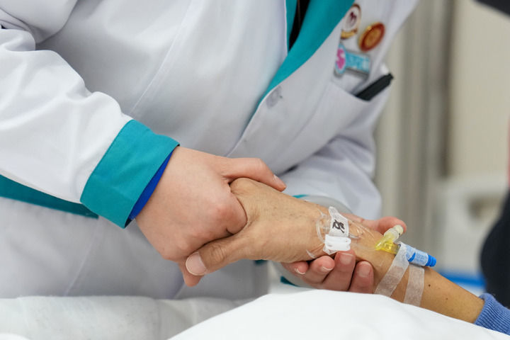 2月5日，在丰台区蒲黄榆社区卫生服务中心，医务社工郭翠红（左一）握着一位70岁的癌症患者的手和她交流。新华每日电讯记者鞠焕宗 摄