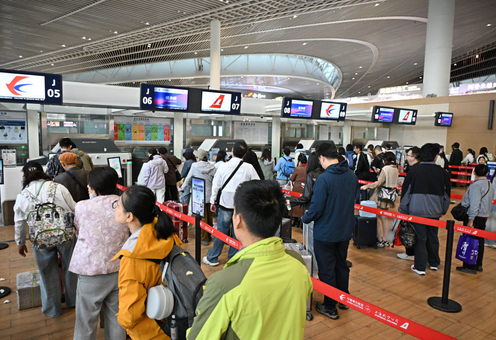 5月1日，旅客在青岛胶东国际机场排队办理值机手续。新华社记者 李紫恒 摄