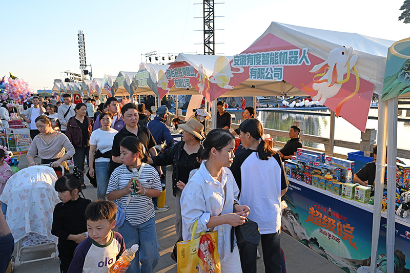安徽省淮南市人民公园,游客在文化集市上选购文创产品。陈彬摄