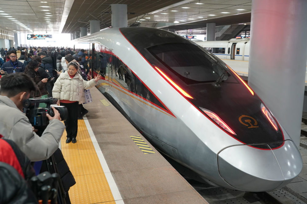 2025年12月26日，西安北站，乘客在西安开往延安的西延高铁C9312次首发列车前拍照留念。新华社记者 邵瑞 摄