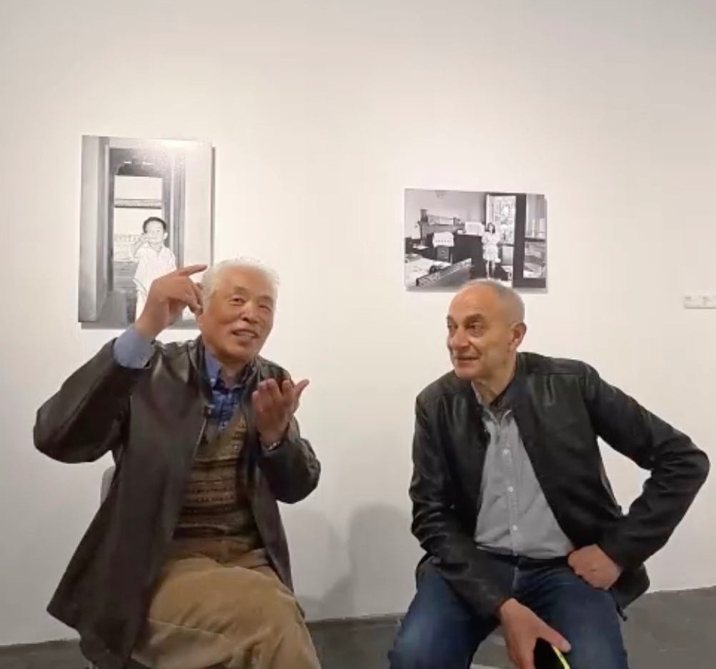 上海多伦现代美术馆“面具之下——中意当代影像艺术交流展”现场，陆元敏和意大利人老安在作品前交流。