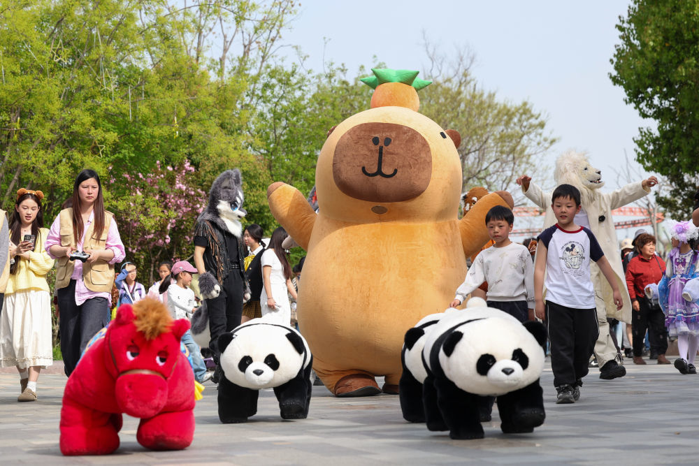 4月4日,游客在湖北省襄阳市华侨城奇幻谷景区观看神奇动物大迁徙巡游表演。新华社发(杨东 摄)