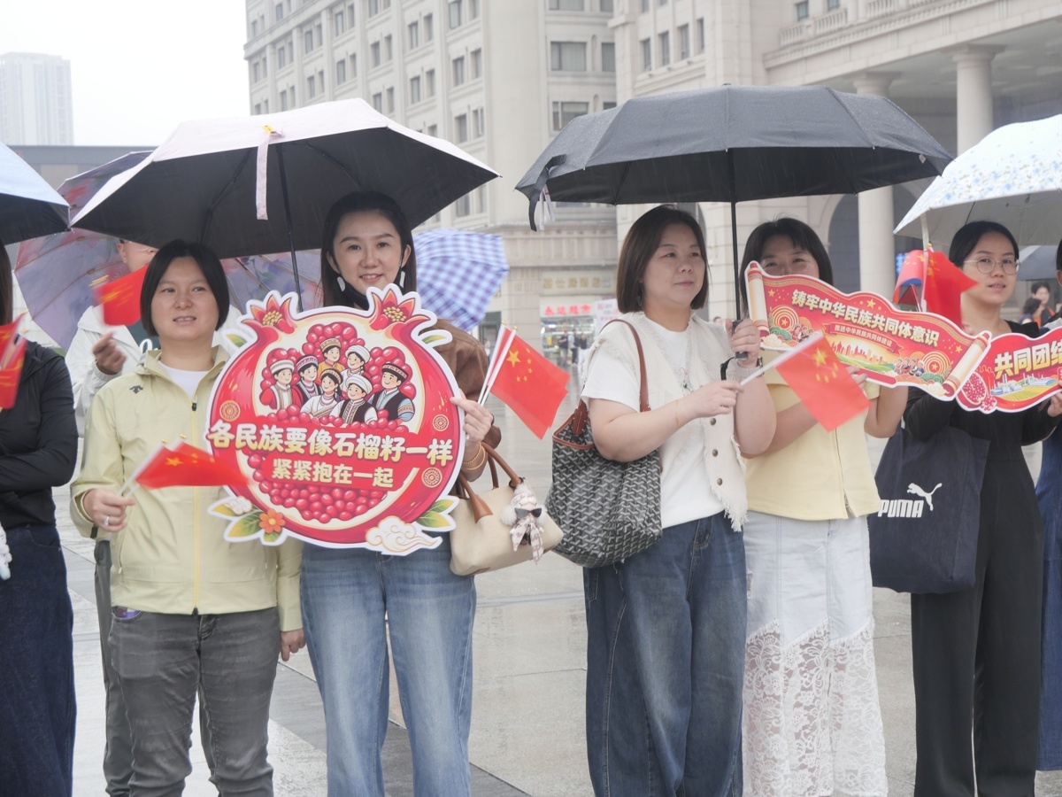 汉口火车站行人举着宣传牌。谢紫莹 摄.JPG