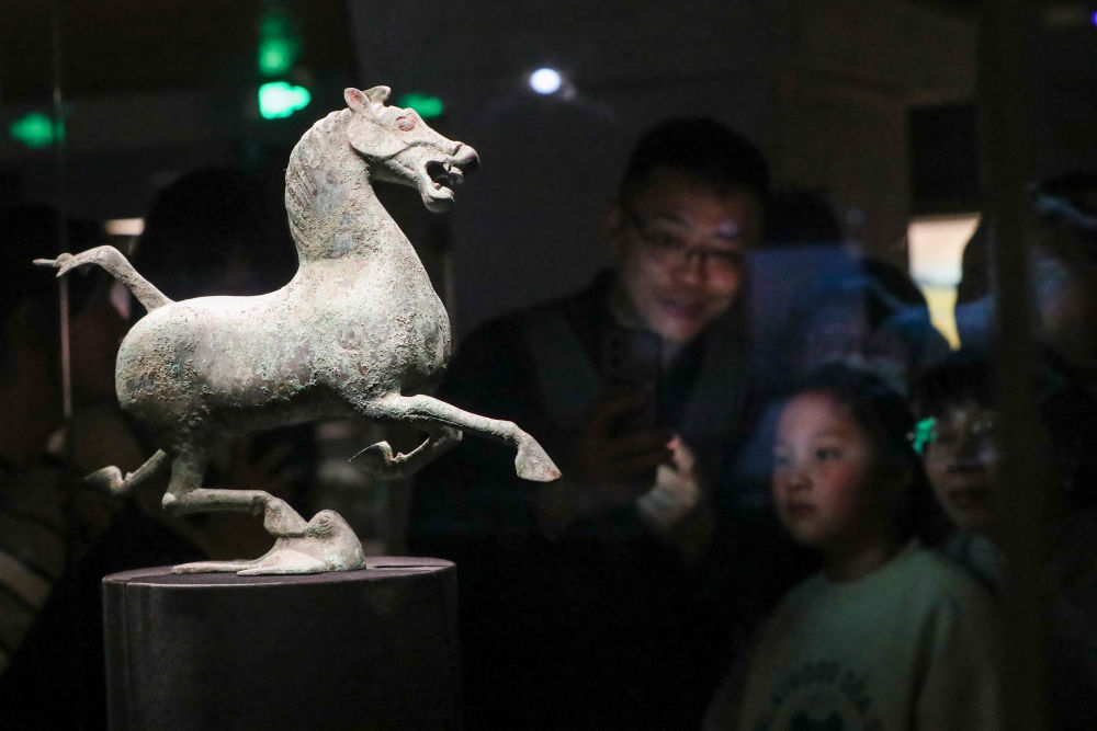 2026年1月26日晚，在甘肃省博物馆二楼丝绸之路文明展厅，观众观看铜奔马（复制品）。新华社记者 郎兵兵 摄