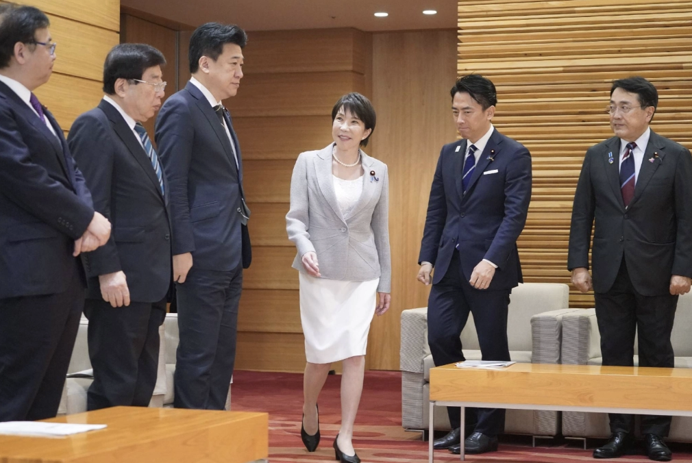 ·高市(右三)走进会议室与新内阁会面,小泉进次郎在列(右二)。(《日本时报》)