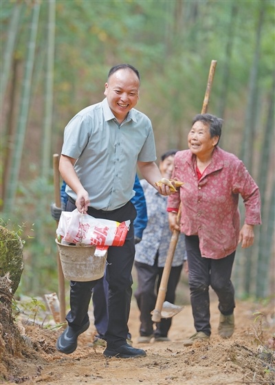 村党支部书记彭展阳(左一)与村民们从山里收工回家。