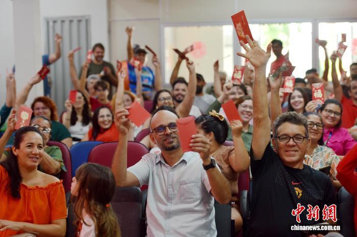 2026年中国农历新年适逢巴西狂欢节。当地时间2月16日，在巴西东北部北里奥格兰德州阿波迪小镇，巴西农户、农业专家和中国农业大学师生们在阿波迪科技小院里联欢，欢乐地展示“红包”。中新社记者 林春茵 摄