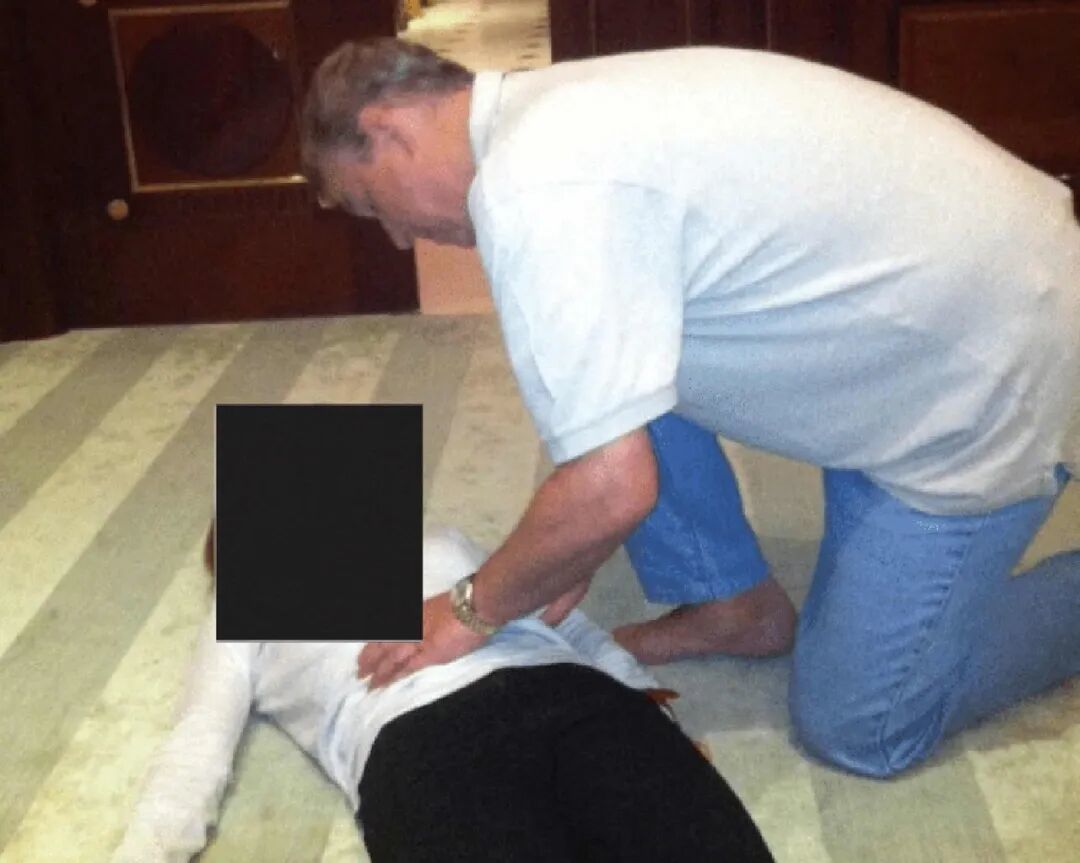 ◆新披露的文件中,安德鲁王子蹲在一名女性身旁。(来源:美国司法部)