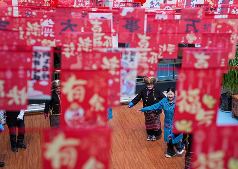 次德吉（中）在山南市桑日县特困人员集中供养中心和其他老人跳锅庄（3月25日摄）。