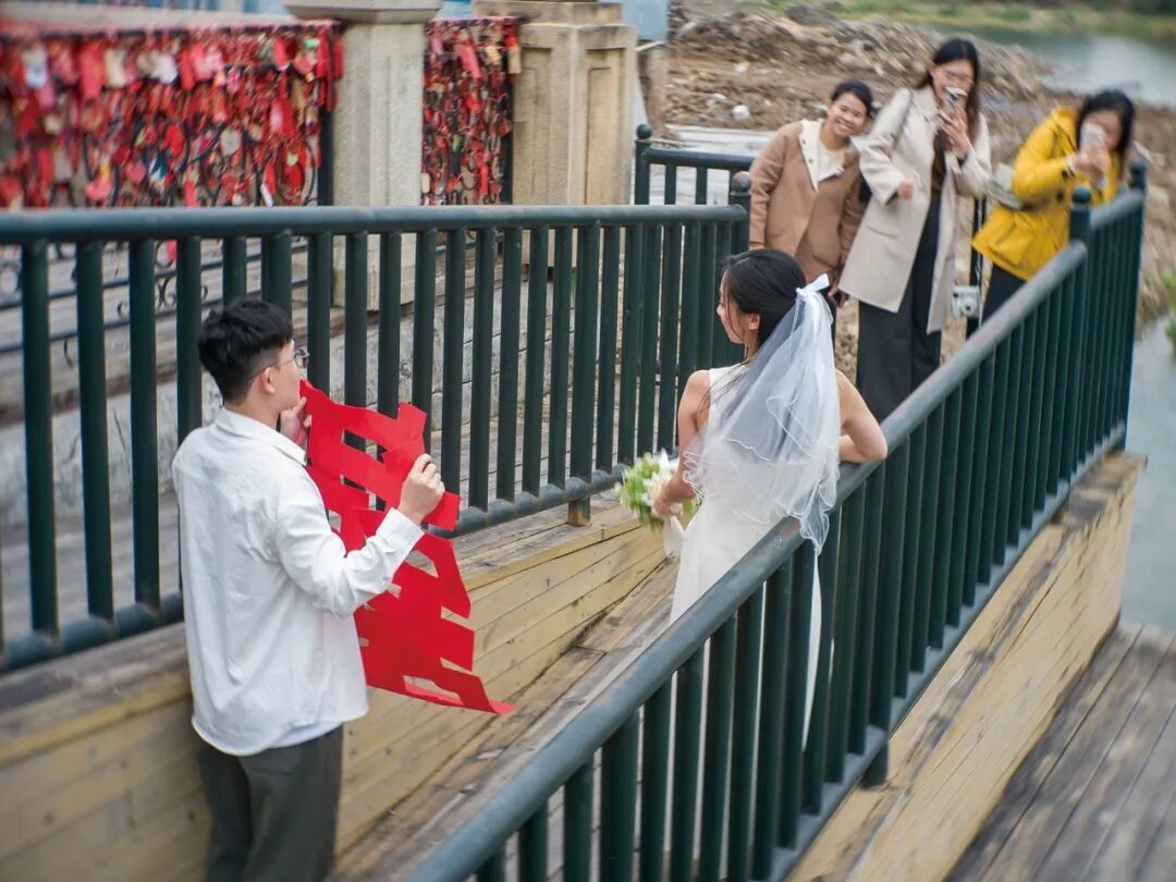 2026年1月24日,广东佛山。顺德欢乐海岸婚姻登记处,一对情侣在朋友的陪伴下到游乐场内领证结婚。(图/阿灿)