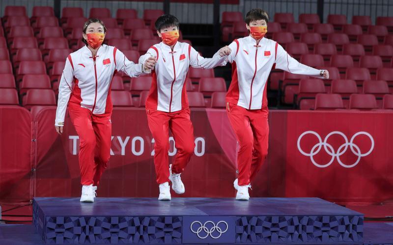 陈梦、孙颖莎和王曼昱携手登顶东京奥运会女子团体赛场,黄海城曾担任过陈梦和孙颖莎的主管教练 (新华社)