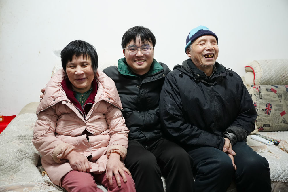 1月29日,冯莫林(中)在位于安康市岚皋县城的家中与父亲冯连许、母亲李兴翠合影。新华社记者 邵瑞 摄