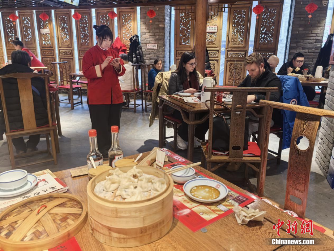 外国食客也在品尝饺子里的“彩蛋”。 石洪宇 摄