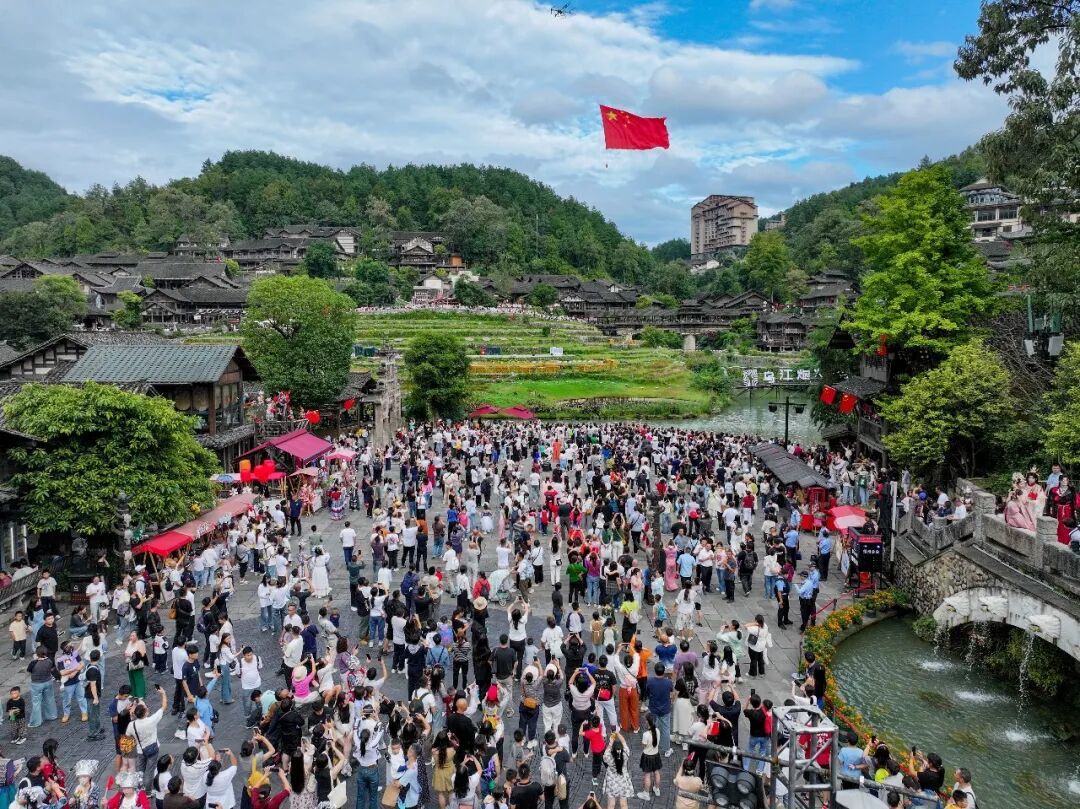 2025年10月1日,游客在贵州省遵义市乌江寨景区观看“红旗礼献”表演。