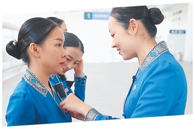 中方列车乘务指导代蕊（右）帮乘务员整理服装。杨永全摄
