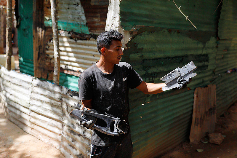 当地时间1月11日，委内瑞拉加拉加斯，一位当地人展示他在一处变电站附近发现的金属碎片。该变电站在美国本月对委内瑞拉的军事行动中受损。（图源自视觉中国）