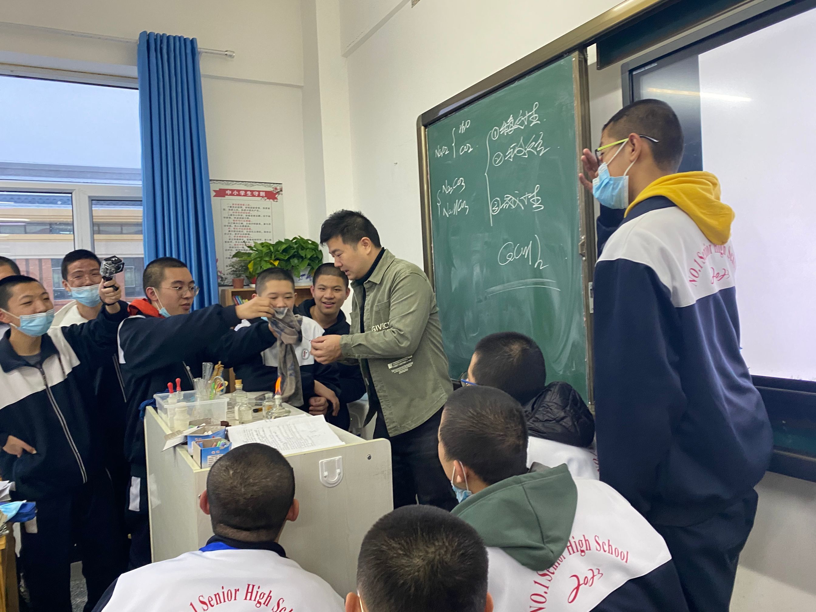 课间学生们围着校长郭胜探讨实验过程。.jpg